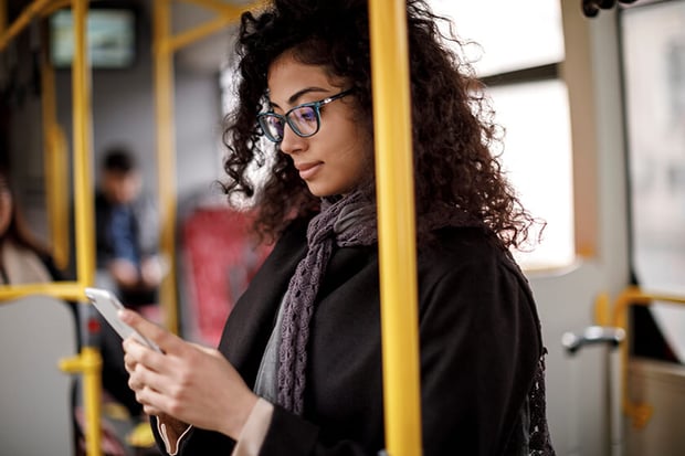 woman on public transportation looking at phone
